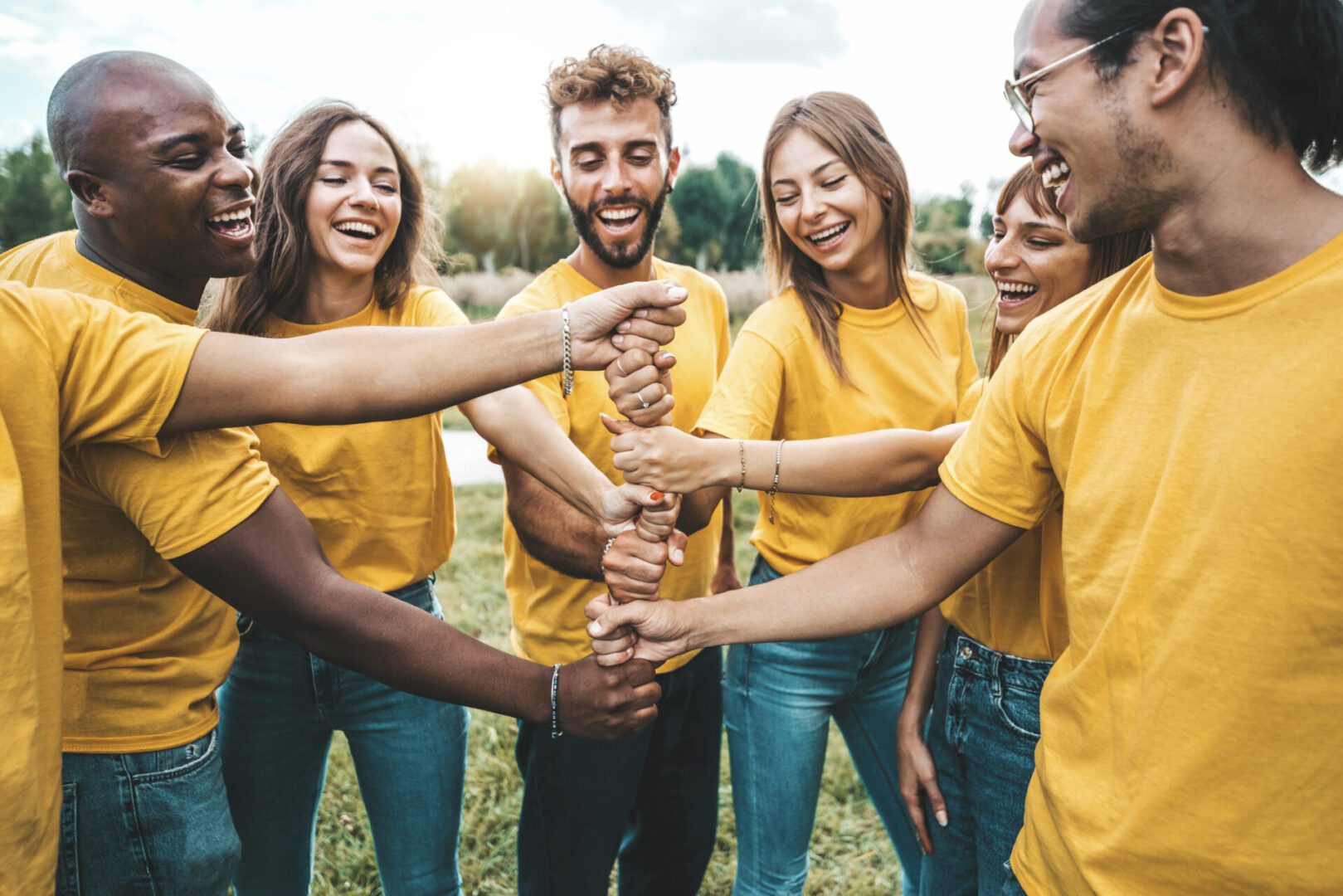 Group of friends in yellow shirts smiling.