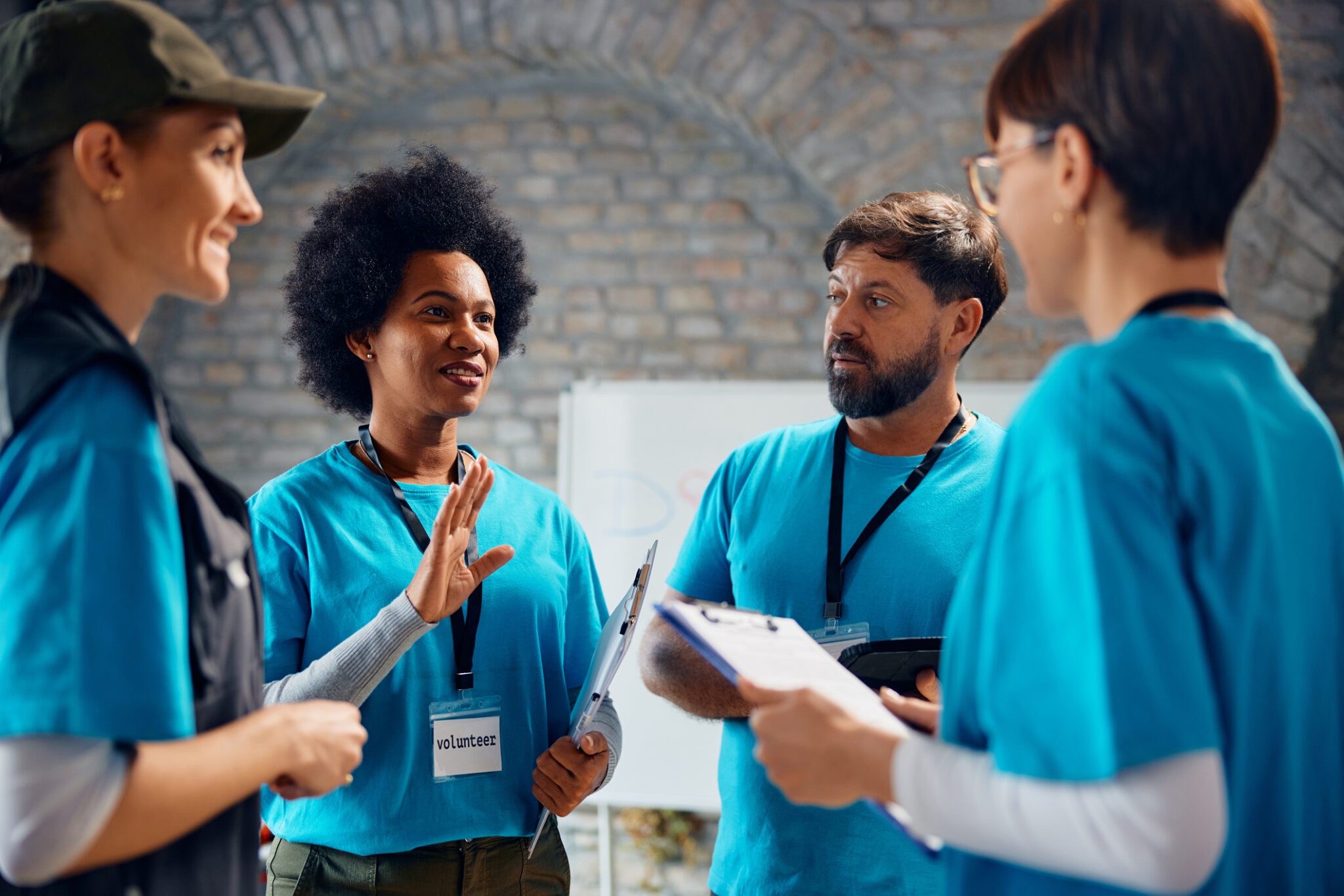 Volunteers in blue shirts having a discussion.